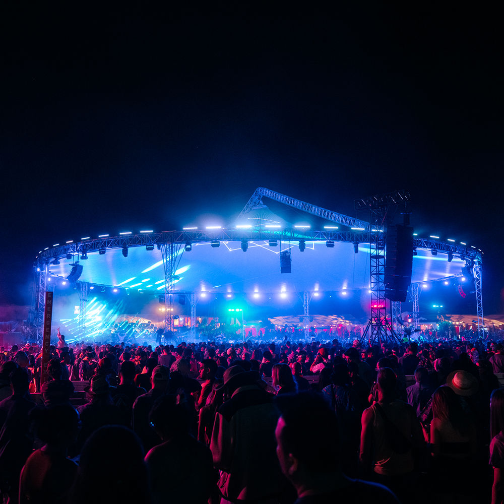 Festival goers and neon lit stage
