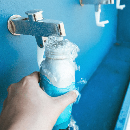 close up photo of recyclable water bottle getting filled up