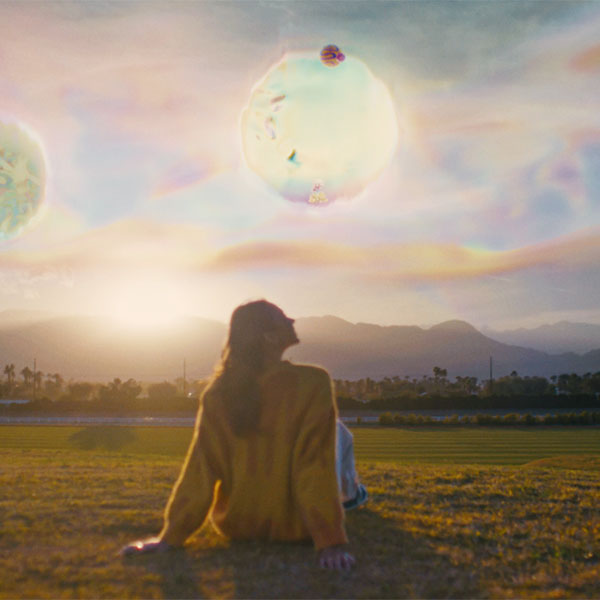 Coachella Canvas festivalgoer sitting on grass