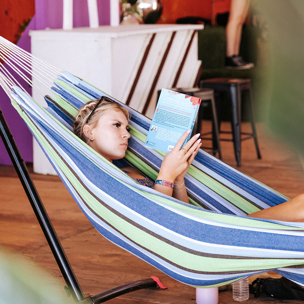 Festival attendee reading in hammock